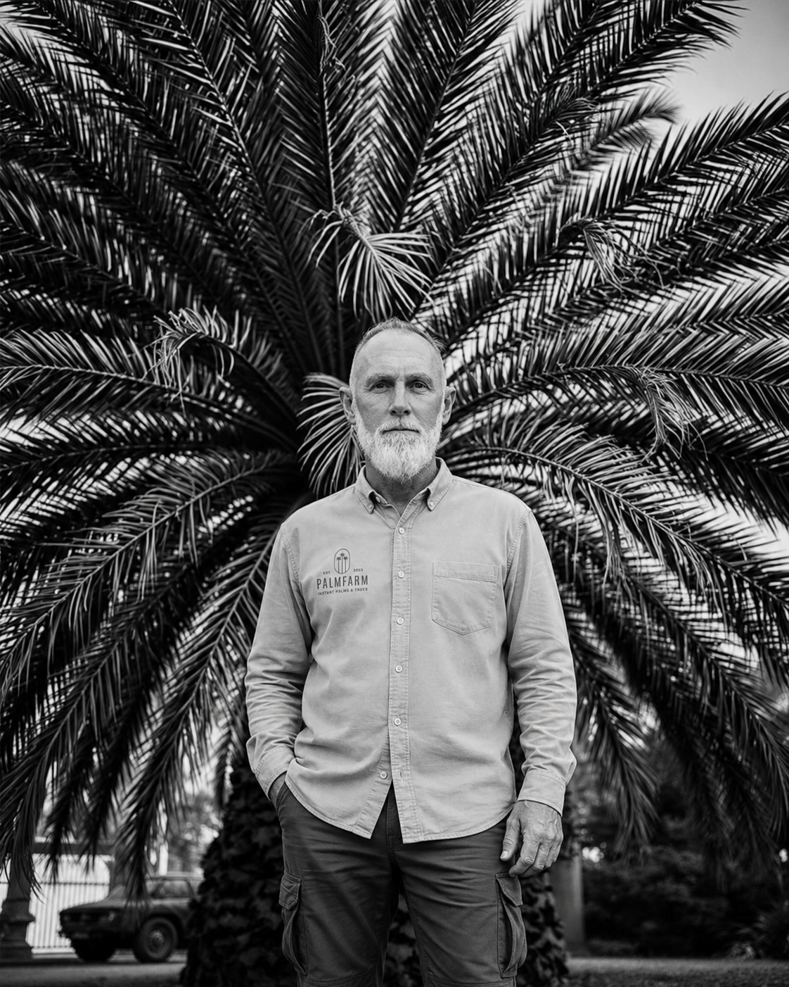 Palmfarm founder standing before a mature palm